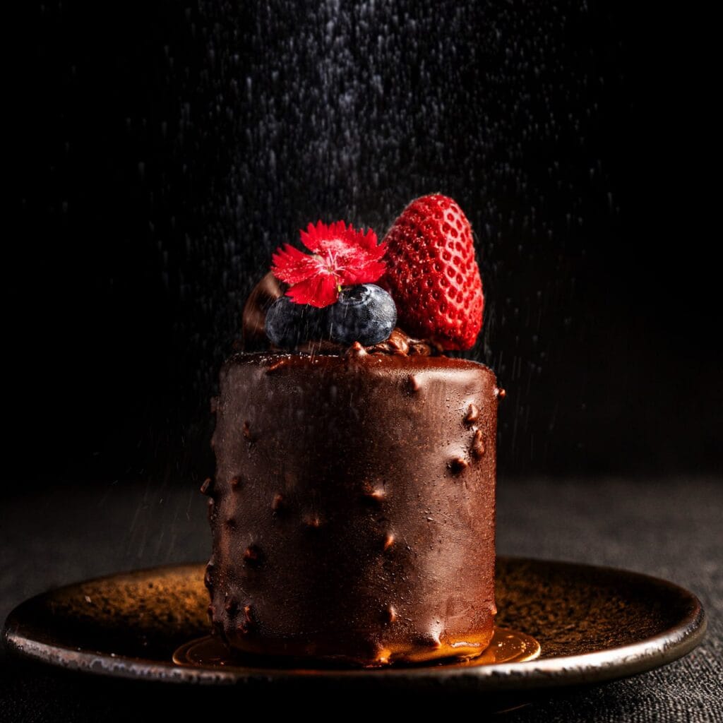 เค้กช็อกโกแลตก้อนเล็กตกแต่งด้วยสตรอว์เบอร์รีและบลูเบอร์รีสด โรยน้ำตาลไอซิ่งอย่างสวยงาม ที่ Davin Cafe คาเฟ่รามอินทรา.