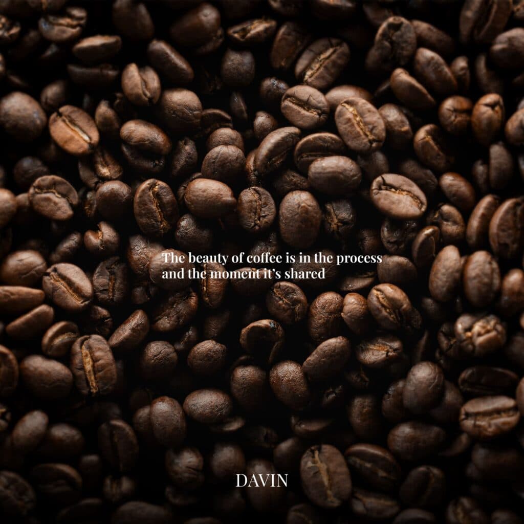 Close-up texture shot of dark roasted coffee beans with the quote: "The beauty of coffee is in the process and the moment it's shared."