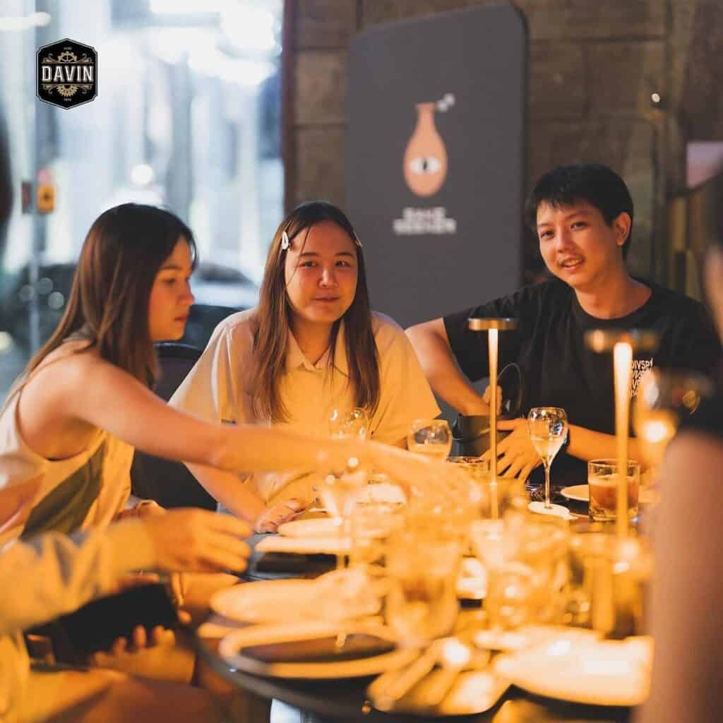 A group of friends enjoying an intimate evening gathering around a dining table with wine glasses, ideal for a private event at the banquet restaurant.