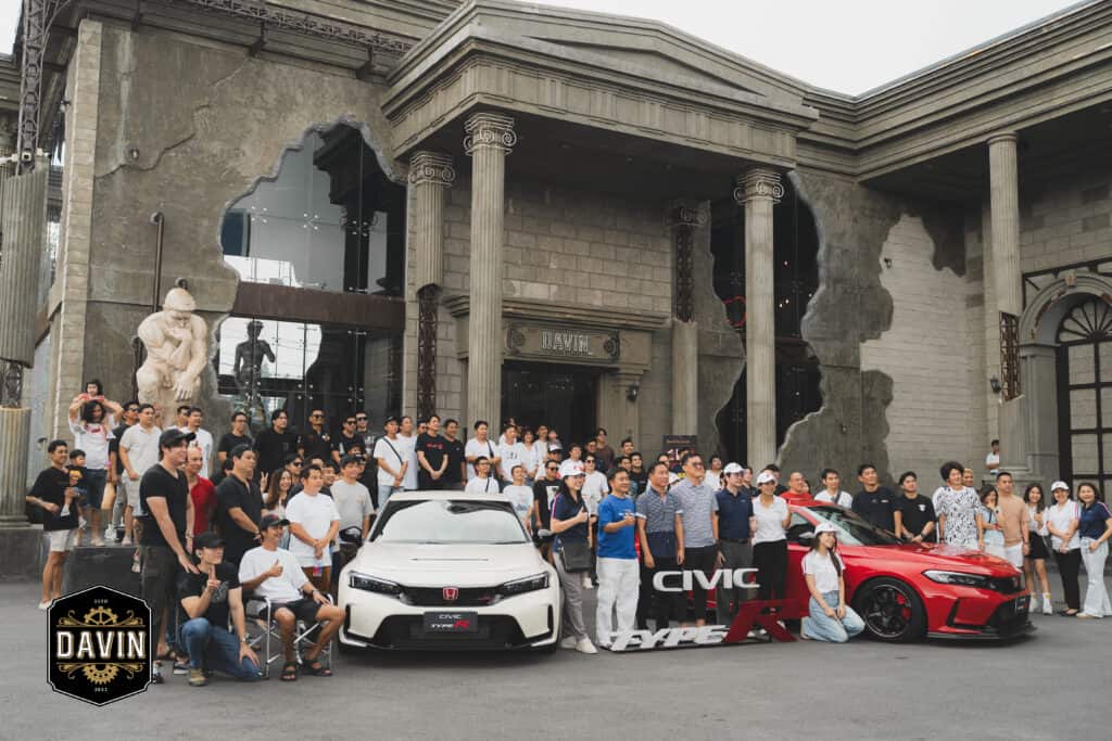 ภาพถ่ายหมู่เจ้าของรถและผู้ชื่นชอบ Honda Civic Type R จำนวนมาก กำลังโพสท่าอยู่หน้า Davin Cafe สถานที่จัดงาน.