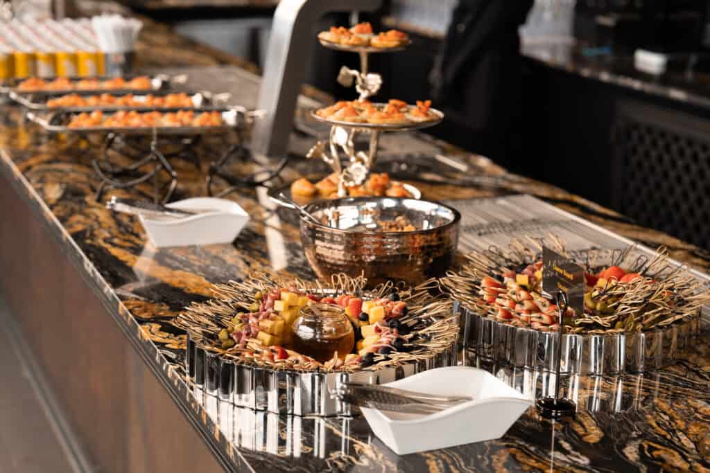 ไลน์อาหารว่างและชีสแพลตเตอร์ที่จัดอย่างประณีตในร้านอาหารจัดเลี้ยง เหมาะสำหรับงานเลี้ยงบริษัทและอีเวนต์ที่ต้องการภาพลักษณ์พรีเมียม