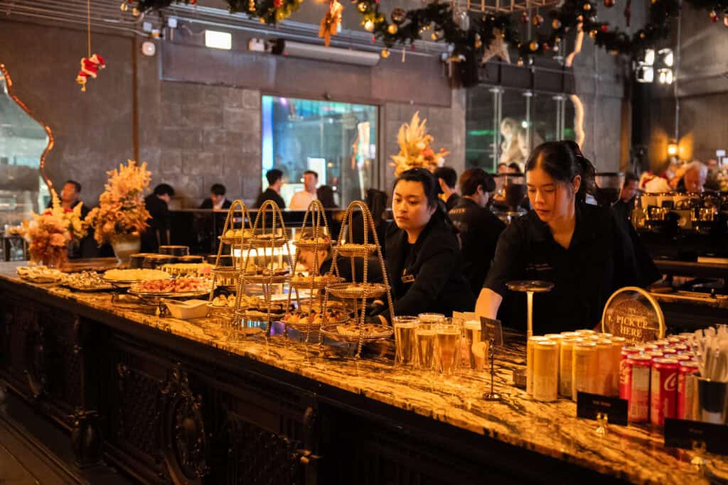 Catering service staff managing food and beverage stations at a restaurant event, ensuring smooth service for a corporate gathering