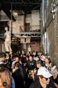 โถงร้านกาแฟในบรรยากาศโมเดิร์นและศิลปะ พร้อมผู้คนมากมายในงานอีเวนต์ The First Ultimate เที่ยวสุดโลก 1.