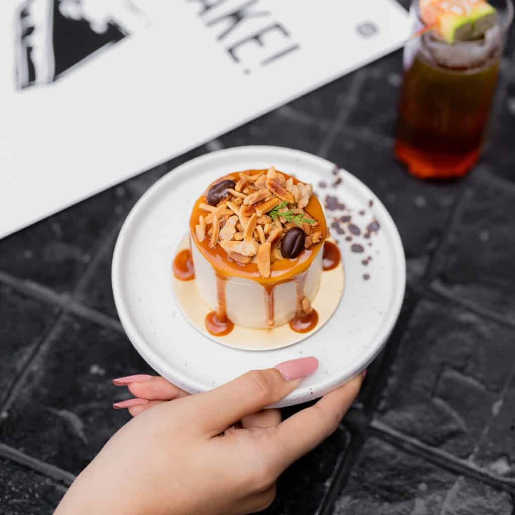 Delicious cake cafe Almond Praline Coffee Cake rich coffee dessert topped with crunchy almond praline and caramel sauce at a premium dessert cafe