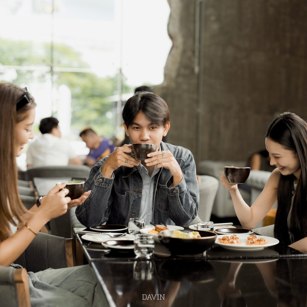 กลุ่มลูกค้ากำลังนั่งดื่มกาแฟและรับประทานอาหารร่วมกันภายใน Davin Cafe ร้านกาแฟ กรุงเทพ ที่ให้บรรยากาศอบอุ่น มีพื้นที่นั่งสบาย และเหมาะสำหรับมื้อพิเศษกับเพื่อน ครอบครัว หรือการจัดเลี้ยงแบบเป็นกันเอง