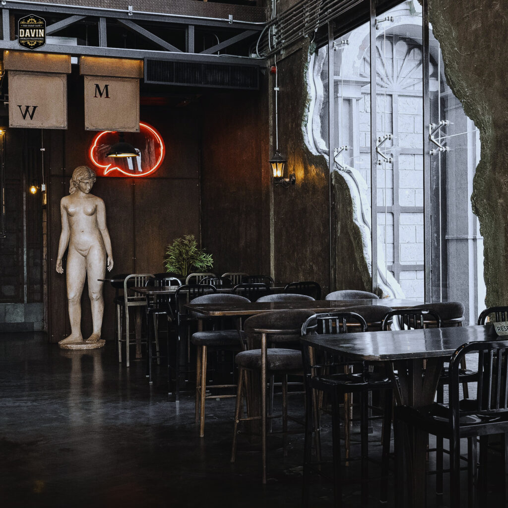 Elegant dining area inside Davin Cafe with European-inspired sculptures, warm lighting, and modern luxury interiors, creating a distinctive Bangkok restaurant venue for private events, corporate gatherings, and memorable group dining experiences.