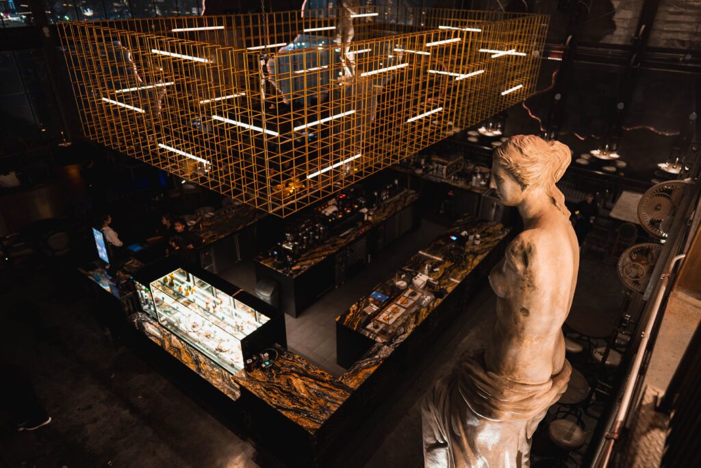 Luxury interior corner at DAVIN CAFE, a good atmosphere restaurant featuring an elegant premium bar, warm lighting, artistic architecture, and an upscale dining and cafe experience perfect for special occasions