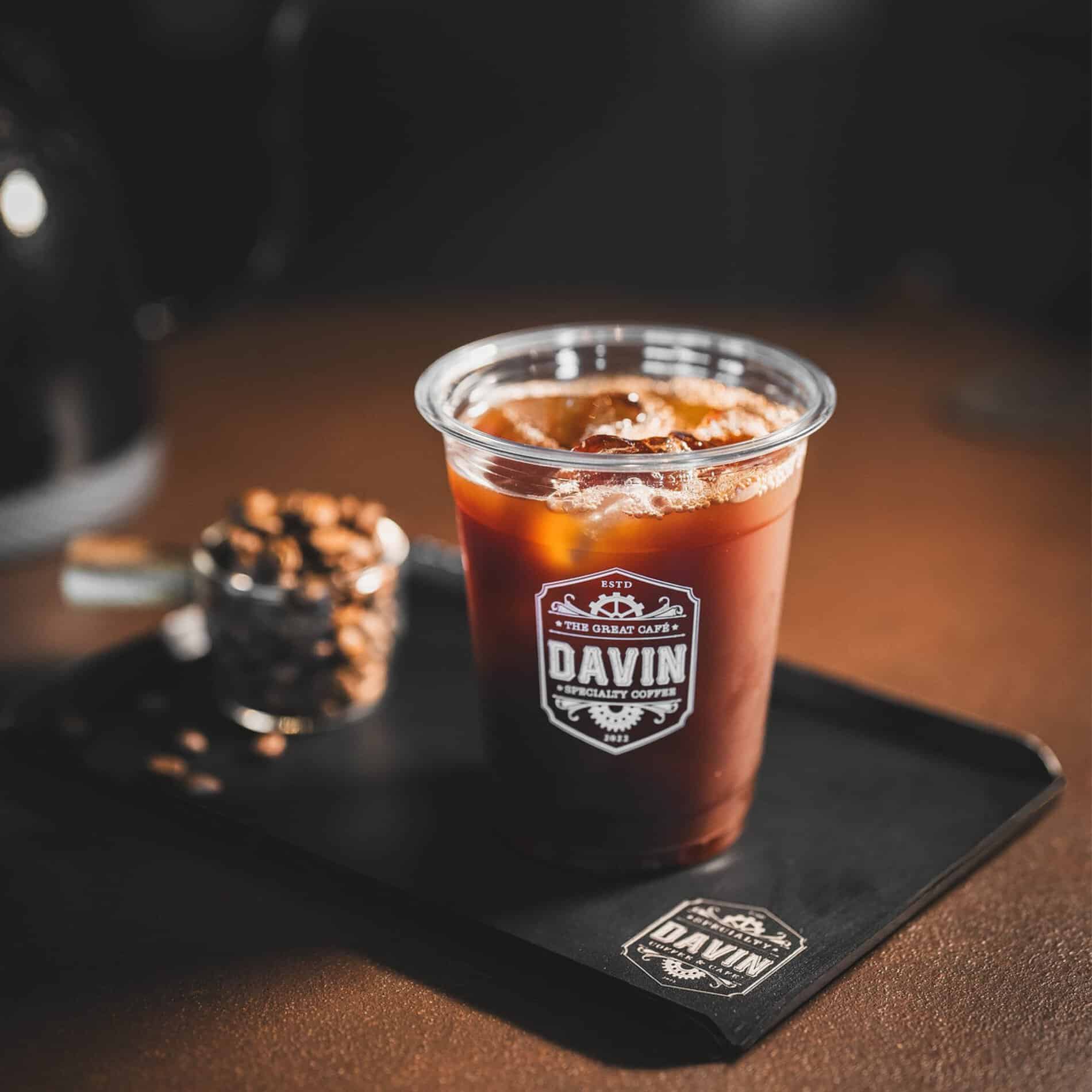 อเมริกาโน่เย็นจาก DAVIN CAFE เมนูกาแฟสกัดร้อนแล้วเติมน้ำและน้ำแข็ง ใช้ประกอบบทความเปรียบเทียบความแตกต่างระหว่าง Cold Brew กับ Americano ในด้านรสชาติ ความเข้มข้น กลิ่นกาแฟ และวิธีการสกัด