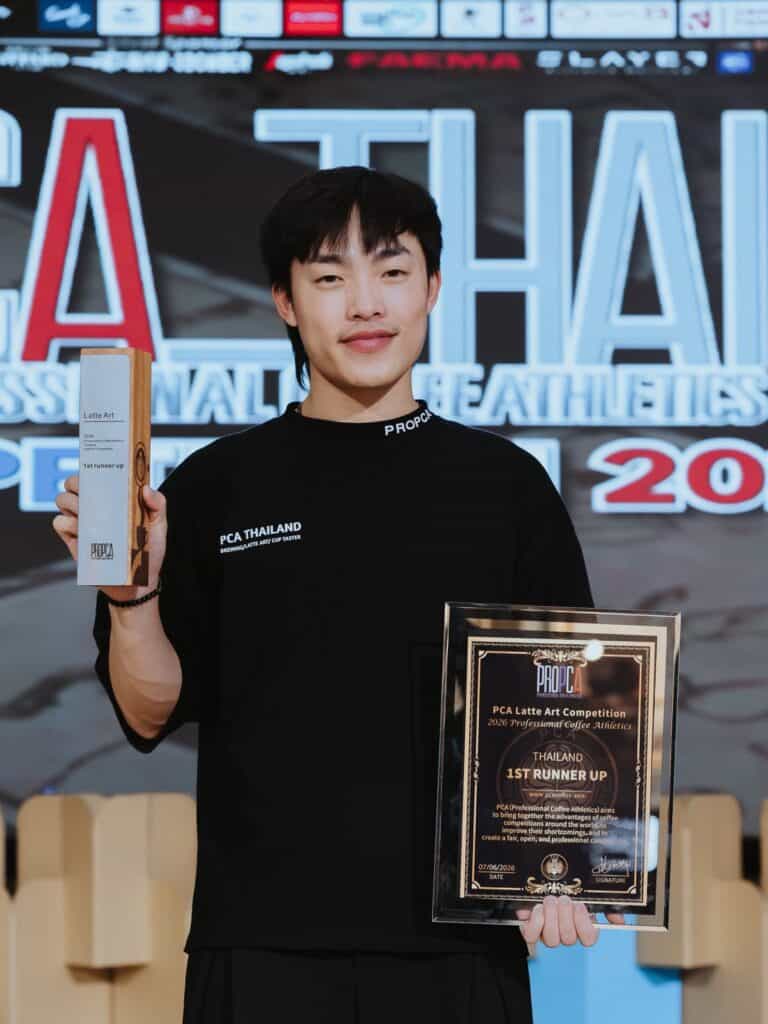 Anawin Tongjai of DAVIN CAFE receiving the 1st Runner-Up award at PCA Latte Art Thailand 2026, demonstrating excellence in latte art, specialty coffee craftsmanship, and nationally recognized barista expertise in Thailand
