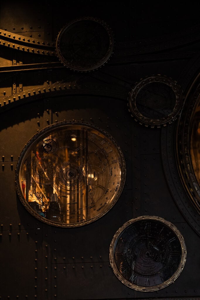 Vintage clock wall decor inside VINSENS, a stylish chill bar in Bangkok with warm lighting, moody interiors, and a distinctive speakeasy atmosphere for relaxed drinks, conversations, and memorable nights out.