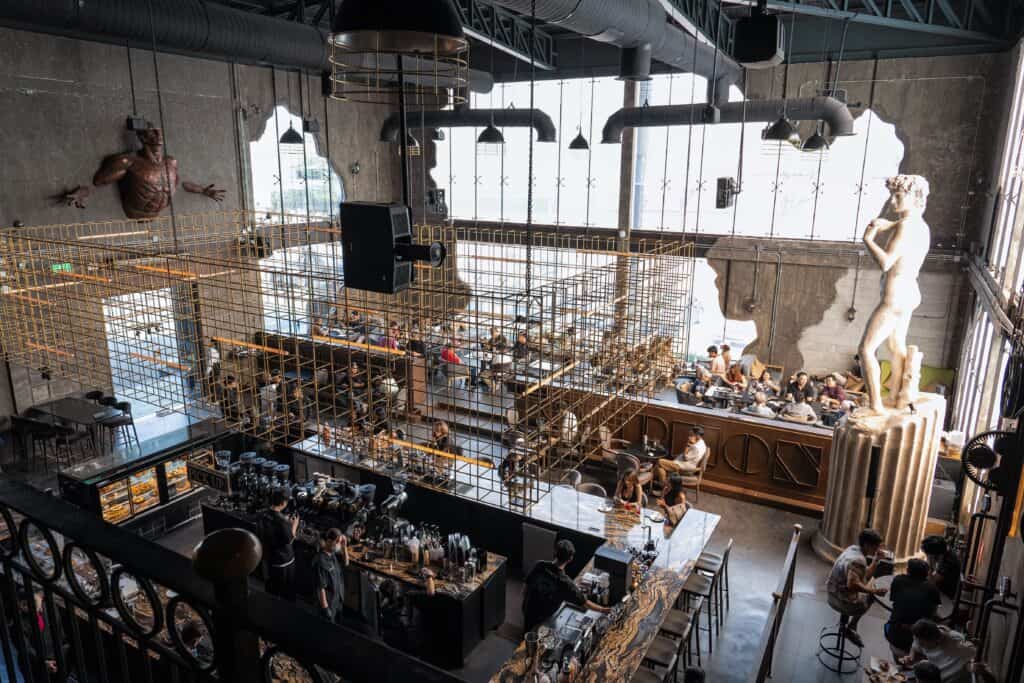 Interior of DAVIN CAFE Bangkok, a premium café renowned for its Matcha Latte, featuring spacious seating, an elegant specialty drink bar, and a unique architectural atmosphere for an exceptional café experience.
