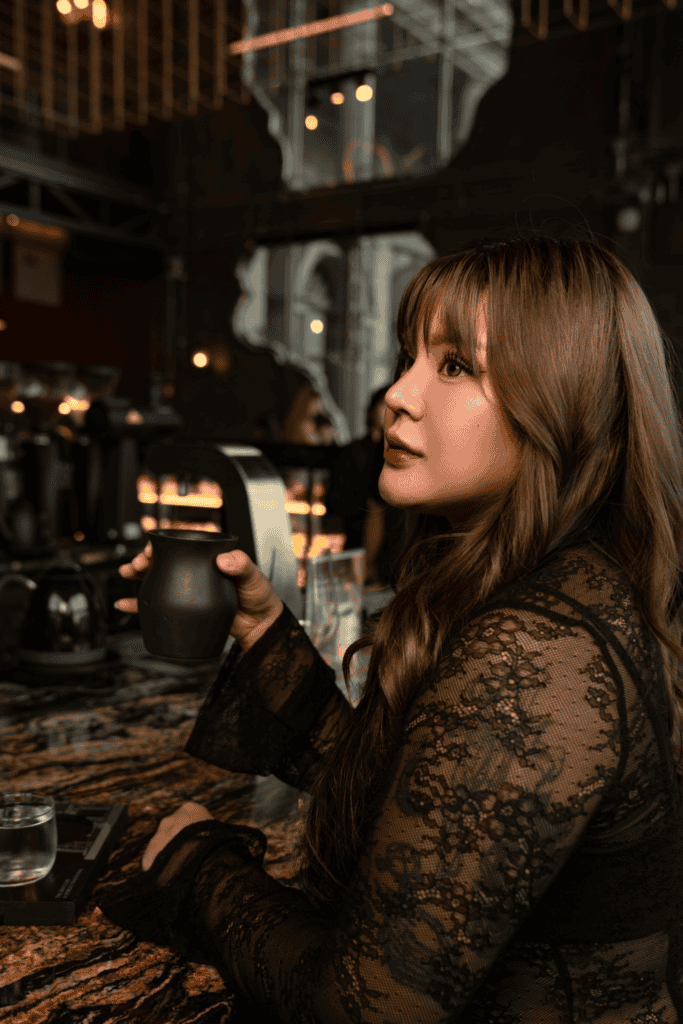 Cafe photo poses with a coffee cup at the DAVIN CAFE bar in a dark fashion editorial setting