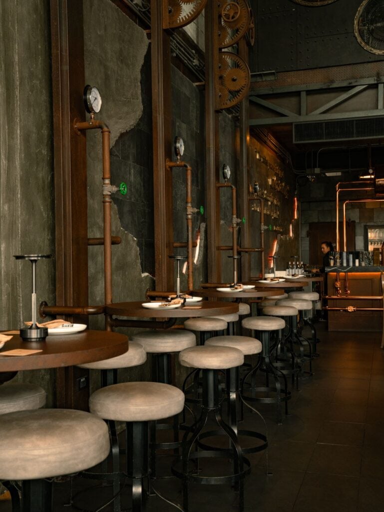 Cozy indoor seating at DAVIN CAFE, a rainy day cafe in Ramintra with warm industrial-style interiors for relaxing on rainy days