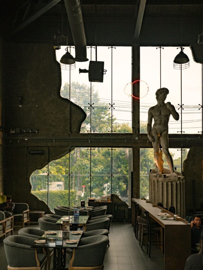 มุมที่นั่งริมกระจกบานใหญ่ภายใน DAVIN CAFE คาเฟ่หน้าฝน รามอินทรา บรรยากาศโปร่ง พร้อมงานตกแต่งสไตล์ยุโรป