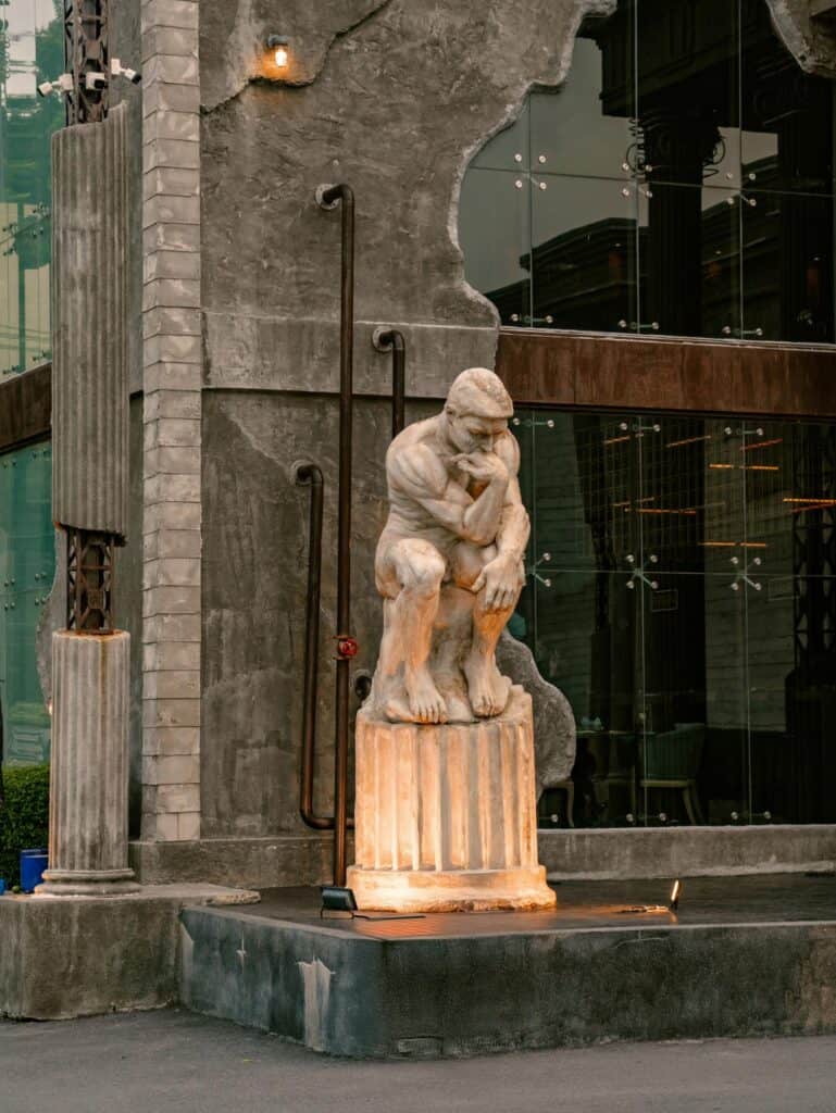DAVIN CAFE restaurant in Pradit Manutham featuring European-style architecture and a classical statue at the entrance